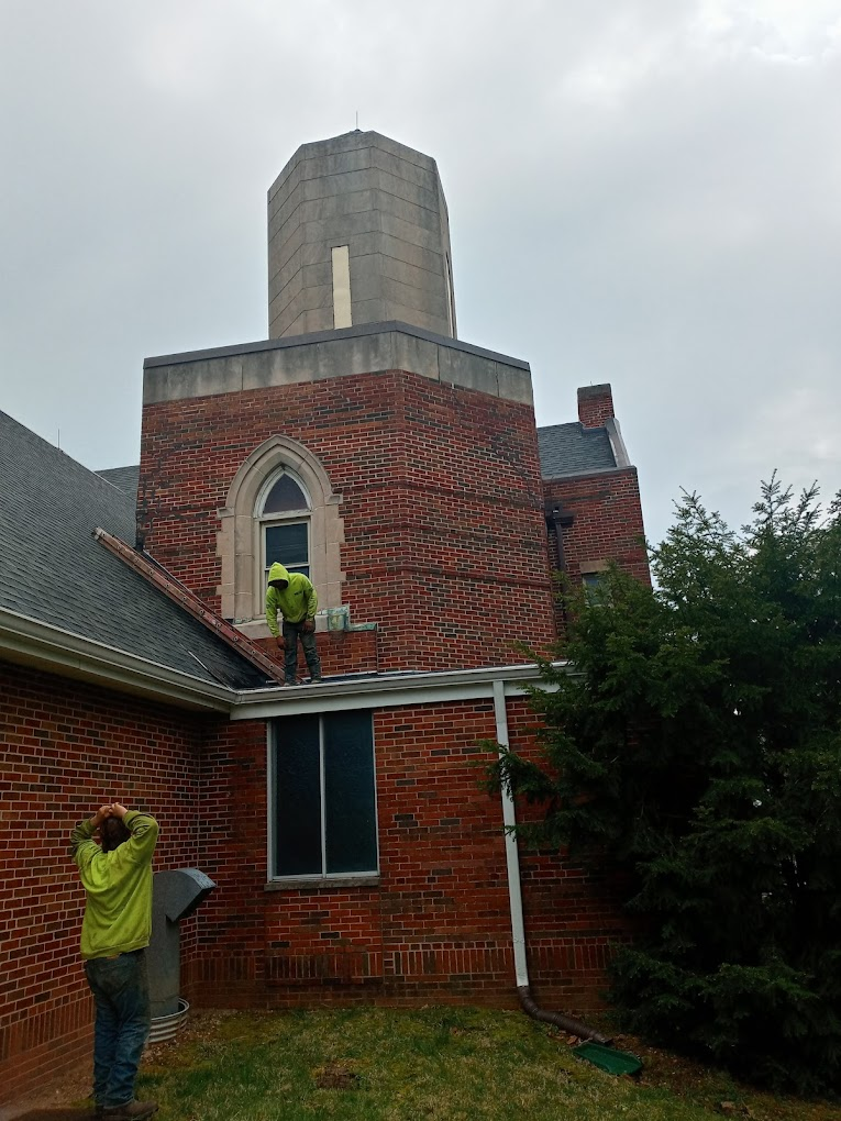 Crew working on a brick tower roof