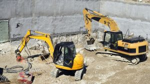 Excavators working beside a concrete foundation