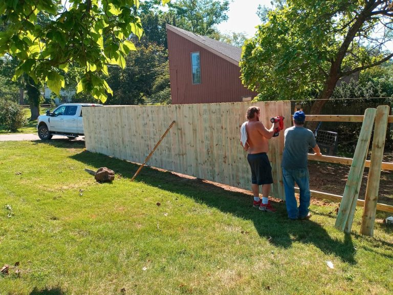 Workers building a wooden fence