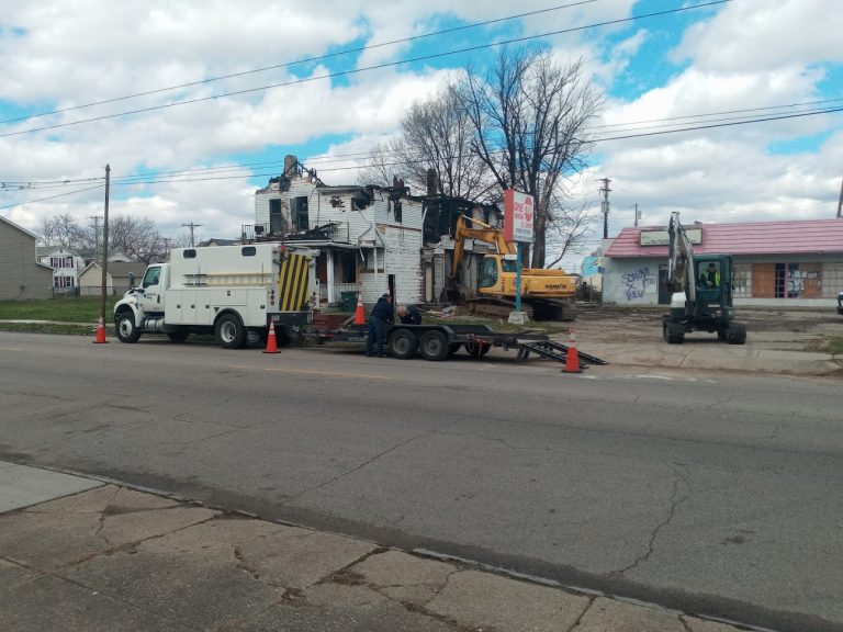 Excavators demolishing a fire-damaged house
