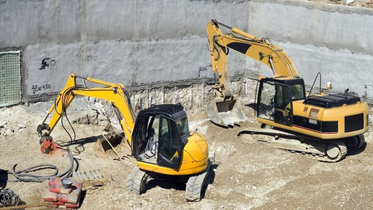 Two excavators working in a trench